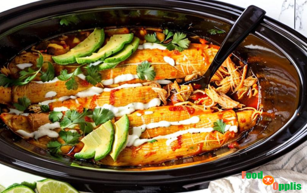 Crock pot filled with chicken enchiladas, topped with melted cheese and garnished with fresh cilantro